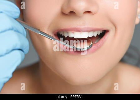 Vista parcial del dentista con espejo dental dientes womans comprobación Foto de stock