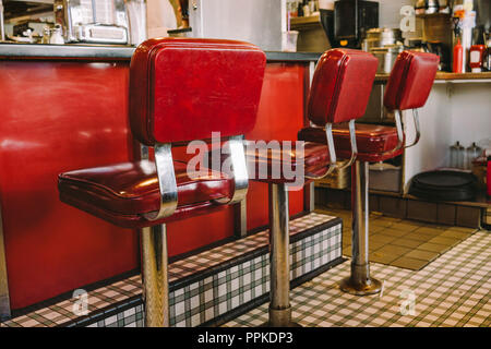 Heces de color rojo a la antigua usanza en un restaurante de estilo retro Foto de stock