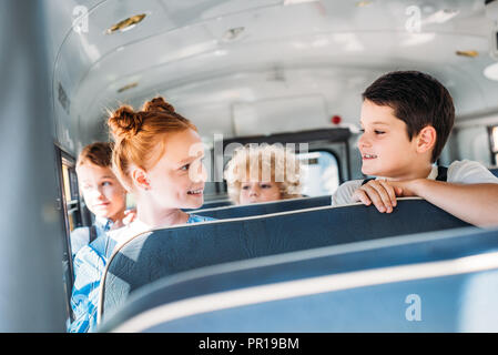 Grupo de alumnos poco feliz viajando en bus de la escuela Foto de stock