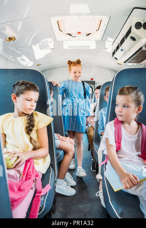Grupo de adorables escolares viajaban en autobús escolar Foto de stock