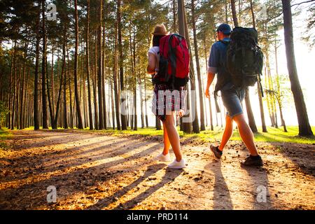 Ruta dura. Hermosa pareja joven senderismo juntos en el bosque mientras disfruta de su viaje.