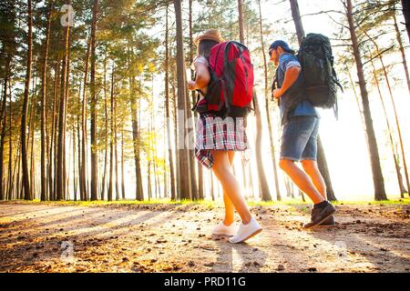 Ruta dura. Hermosa pareja joven senderismo juntos en el bosque mientras disfruta de su viaje.