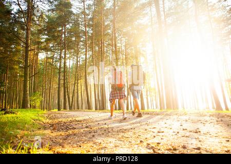 Ruta dura. Hermosa pareja joven senderismo juntos en el bosque mientras disfruta de su viaje.