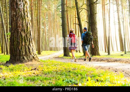Ruta dura. Hermosa pareja joven senderismo juntos en el bosque mientras disfruta de su viaje.