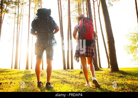 Ruta dura. Hermosa pareja joven senderismo juntos en el bosque mientras disfruta de su viaje.