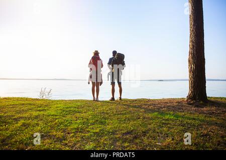Ruta dura. Hermosa pareja joven senderismo juntos en el bosque mientras disfruta de su viaje.