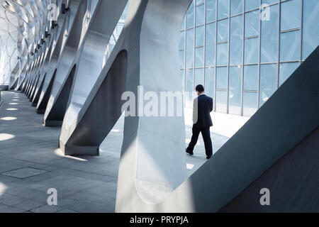 China, Shenzhen, moderna arquitectura y empresario caminando