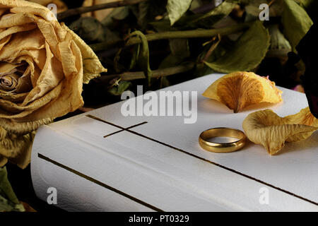 La Santa Biblia blanca, un anillo de bodas y rosas en seco. Hermosa imagen conceptual pero tocando por fallecimiento, matrimonio, divorcio y votos matrimoniales.