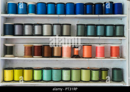 Colorido/hilo de coser hilo de coser que se organizan en la estantería. Foto de stock