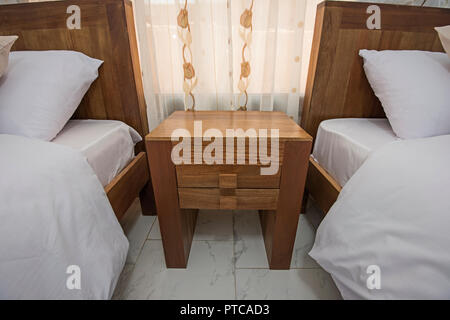 Corte cuadrado cama individual con cabecera de madera marrón y mesa lateral  con lámpara moderna Fotografía de stock - Alamy