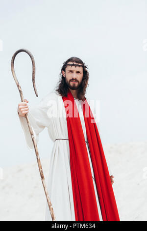 Imagen recortada de Jesús de túnica y fajín rojo en el desierto permanente  Fotografía de stock - Alamy