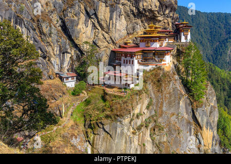 Monasterio de Tiger's Nest, Paro Taktsang, situado en lo alto de un acantilado en paro, Bhután, hermosos paisajes y el telón de fondo de montañas y árboles Foto de stock