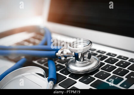Estetoscopio en el teclado del portátil. Cuidado de la salud o del concepto de seguridad Foto de stock
