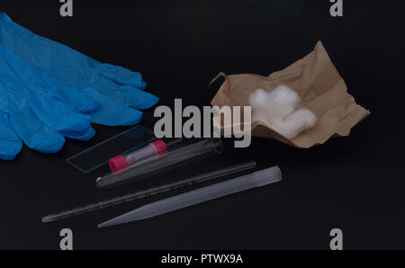 Conjunto de médicos para extraer sangre de un dedo sobre un fondo negro Foto de stock
