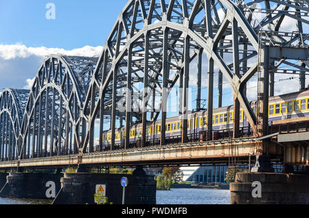 Ferrocarril letón pasando el puente del ferrocarril, en Riga, Letonia, sobre el río Daugava
