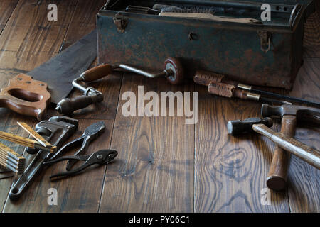 Herramientas antiguas y sucio toolbox en superficie de madera oscura