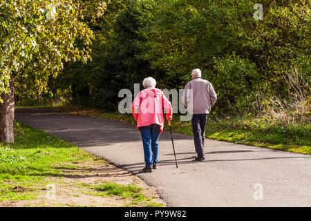 Una pareja madura de un paseo a lo largo de una ruta arbolada en Teddington Lock,Londres,Inglaterra,Reino Unido Foto de stock