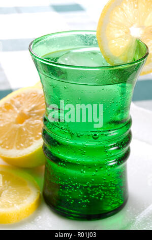 Deliciosa bebida de verano fresco en un cristal verde con hielo y Limón Foto de stock
