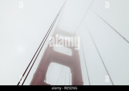 Bajo el ángulo de la cámara disparo en la estructura de la Torre del Puente Golden Gate en la niebla, San Francisco, California, EE.UU. Foto de stock
