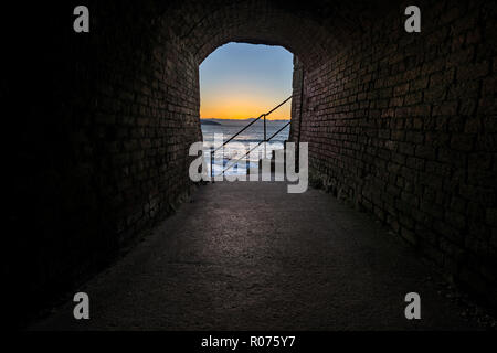 El sol naciente asoma a través de un pequeño tramo de túnel en Charlestown, Cornwall. Este túnel habría sido una parte crucial del puerto.