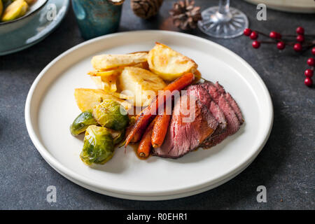 Cena con asado de ternera, zanahorias, coles de bruselas y gravy Foto de stock