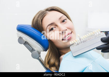 Clínica Dental. La recepción, el examen del paciente. Cuidado de los dientes. Dentista con muestras de color de diente elegir la sombra para mujeres en dental de los dientes del paciente cl Foto de stock