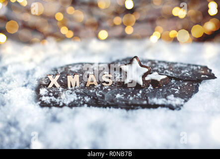Decoración de Navidad con pan de jengibre, estrellas de madera y cartas de Navidad en la nieve. Foto de stock