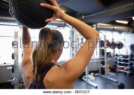 Mujer hacer ejercicio con balón medicinal en el gimnasio