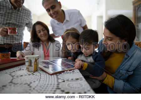 En multigeneración Latinx familia mirando el álbum de fotos