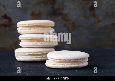Macarons franceses blancos sobre fondo rústico