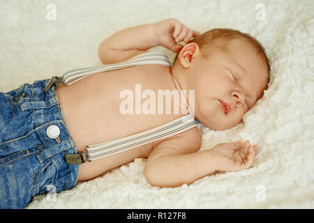 La moda en jeans de bebé recién nacido duerme en la cama. Moda para niños  Fotografía de stock - Alamy