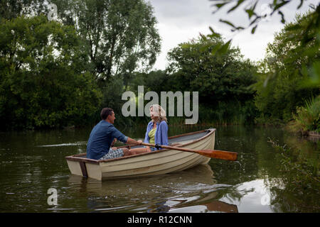 Pareja madura en bote a remo en el lago rural Foto de stock