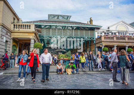 Los turistas pasar su tiempo en el mercado de Covent Garden, una de las zonas más populares de tiendas y sitios de interés turístico de Londres, Reino Unido Foto de stock