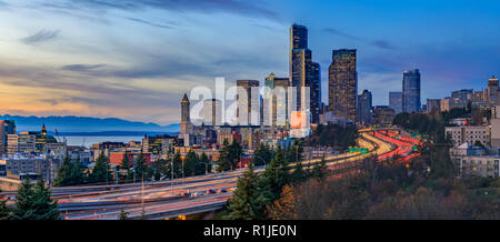 Panorama de Seattle Downtown skyline más allá de la I-5, I-90 Freeway interchange al atardecer con larga exposición traffic trail luces desde el Dr. Jose Rizal o