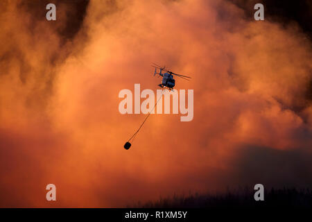 Smokey sunset y helicópteros de lucha contra incendios, en Burnside, Dunedin (Isla del Sur, Nueva Zelanda