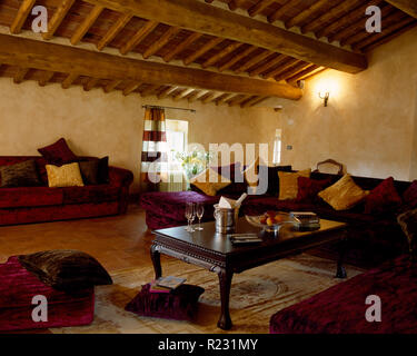 Techo con vigas de madera rústica en Italiano, sala de estar con sofás rojos