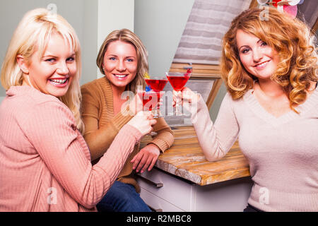 Tres mujeres vasos tintineo Foto de stock