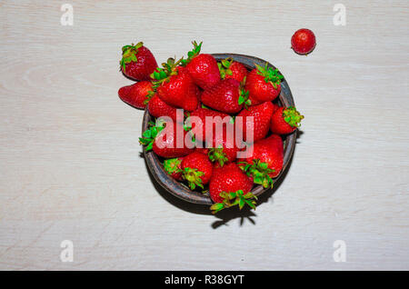 Fresas rojas maduras y frescas sobre vasija de greda