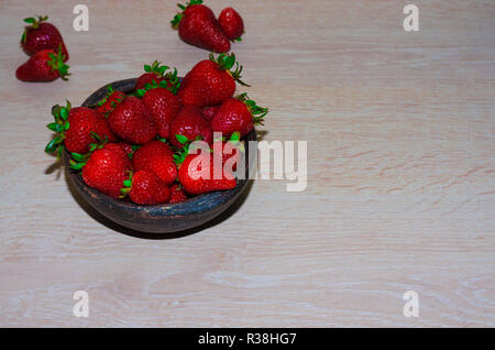 Fresas rojas maduras y frescas sobre vasija de greda