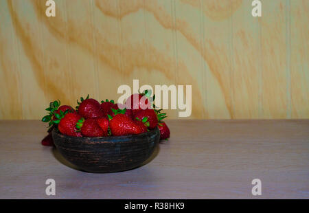 Fresas rojas maduras y frescas sobre vasija de greda