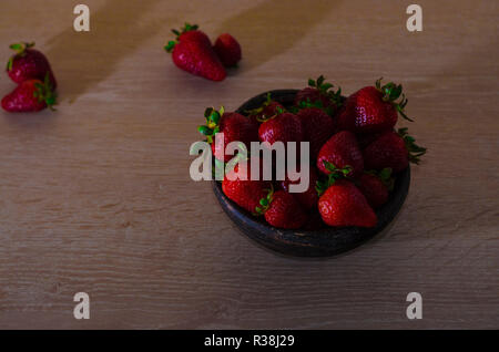 Fresas rojas maduras y frescas sobre vasija de greda