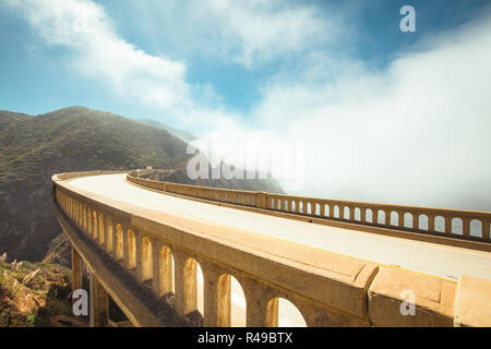 Vista panorámica del casco histórico de Bixby Creek mundialmente famoso puente a lo largo de la autopista 1 en un día soleado, con niebla, en verano, el Condado de Monterey, California, EE.UU. Foto de stock
