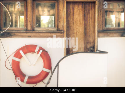 Salvavidas naranja en vintage barco blanco en puerto