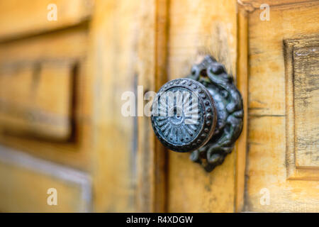 Puerta de madera antigua con un pomo de hierro redondo, de cerca