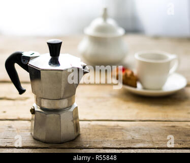 Cafetera italiana tradicional en el fondo de madera con taza de porcelana,  platillo, dulces y el azúcar en el fondo del tazón de Fotografía de stock -  Alamy