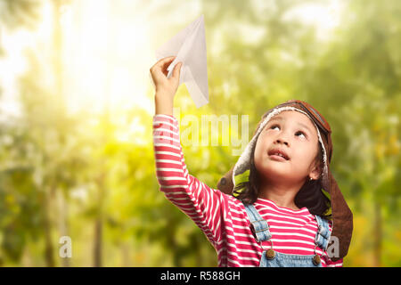 Asia alegre niño jugando con avión de papel Foto de stock