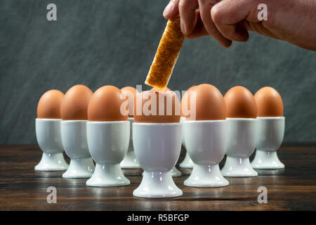 Huevos cocidos en tazas de huevo y zumo de naranja sobre la mesa de madera  Fotografía de stock - Alamy