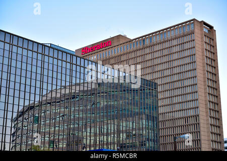 Es un edificio alto, el Sheraton Denver Downtown con reflejos en windows