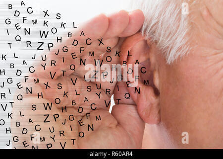 Close-up de un hombre intentando escuchar Foto de stock