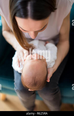 Vista aérea de la madre abrazando a su hijo recién nacido en casa